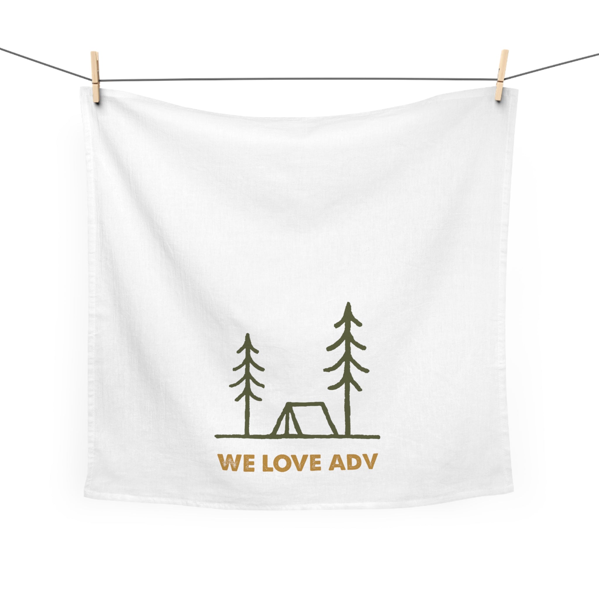 White towel with camping design and 'WE LOVE ADV' text hanging on a line.